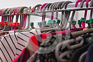 Close up on hangers with various women clothing in charity thrift shop