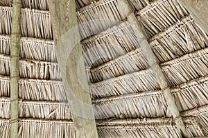 Close-up of hanging edge of thatched umbrellas on beach