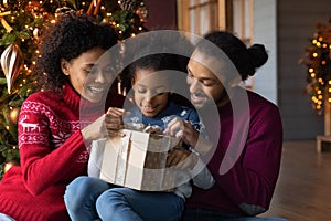 Close up happy African American family unpacking Christmas gift