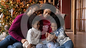 Close up happy African American family using smartphone, winter holidays