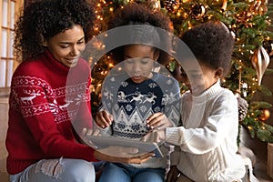 Close up happy African American family using tablet on Christmas