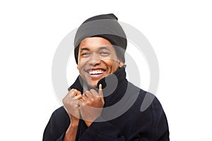 Close up happy african american man keeping warm with winter jacket and beanie against white background