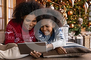 Close up happy African American woman with daughter using tablet