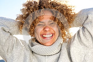 Close up happy african american woman laughing with hands behind head