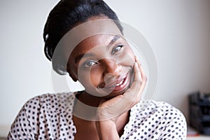 Close up happy african american woman leaning with head in hand