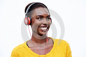 Close up happy african american woman listening to music with headphones against isolated white background