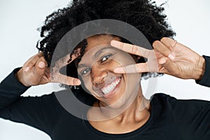 Close-up of happy African American woman making victory gesture