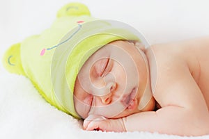 Close up happy baby girl new born sleeping in green hat