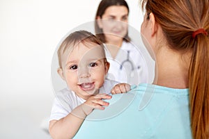 Close up of happy baby with mother and doctor