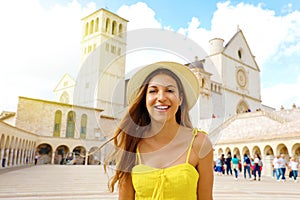 Close up of happy beautiful tourist woman in Assisi town at Basilica of Saint Francis, Umbria, Italy