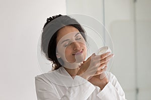Close up happy beautiful woman applying moisturizing hand cream