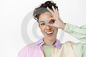 Close up of happy brunette woman shows OK okay gesture, smiling positive, praise and compliment, leave positive review