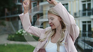 Close up happy business woman dancing with phone in hand outdoor