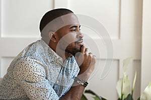 Close up happy calm young african american thoughtful guy. photo