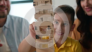 Close-up happy caucasian family mom dad son having fun playing tower caring parents play with beloved child boy in