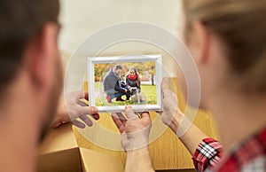 Close up of happy couple looking at family photo