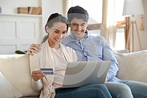 Close up happy couple paying by credit card online together