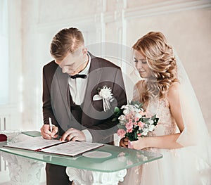 Close up. the happy couple by signing a marriage contract.