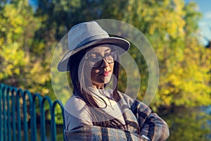 Close up of happy emotionally brunette woman with long hair and hat, smiling at camera