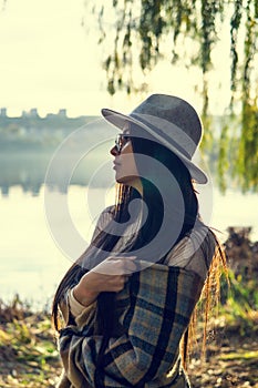 Close up of happy emotionally brunette woman with long hair and hat, smiling at camera