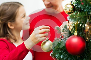Close up of happy family decorating christmas tree