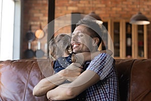 Close up happy father hugging little daughter, enjoying tender moment