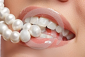 Close-up happy female smile with healthy white teeth, bright red lips make-up. Cosmetology, dentistry and beauty care