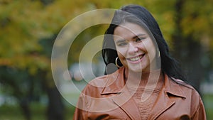 Close-up happy friendly attractive young hispanic woman standing in park looking at camera cute smiling flirting