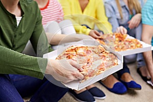 Close up of happy friends eating pizza at home