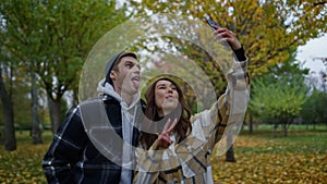 Close up happy funny lovers taking selfie with golden autumn on background.