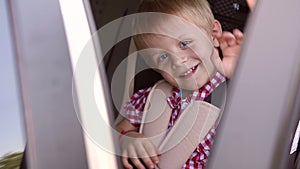 Close-up of happy little boy`s face in car seat in summer. Child safety.