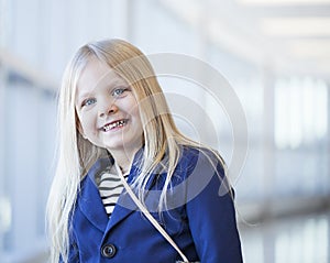 Close-up of happy little girl wearing dress and blue jacket