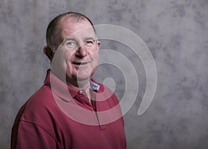 Close up of a happy mature man on a grey background