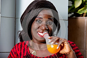 Close-up of a happy mature woman with bottle of fruit juice
