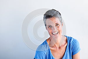 Close up happy mature woman laughing against white background