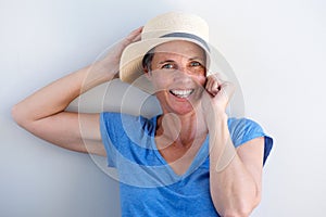 Close up happy mature woman smiling with hat against white background