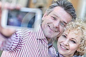 Close-up of happy middle-aged couple taking selfie through smart phone