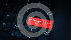 Close-up HAPPY NEW YEAR 2021 button with red color on a black laptop keyboard background.