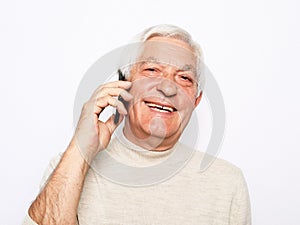 close up of happy old man using smartphone over white background.