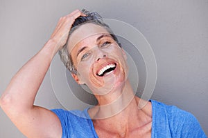 Close up happy older woman laughing with hand in hair