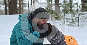 Close-up of a happy owner and his dog during a walk in the winter forest