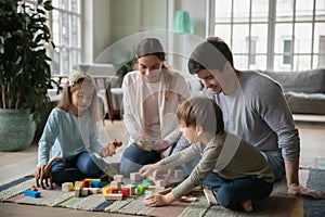 Close up happy parents and two kids playing with toys