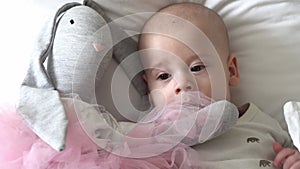 Close-up Happy playful kid 6 month old. Newborn boy looking at camera after bath shower on white soft bed. baby child