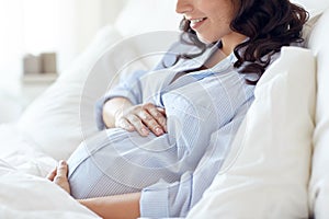 Close up of happy pregnant woman in bed at home