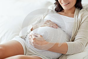 Close up of happy pregnant woman in bed at home