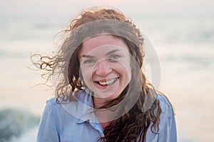 Close up of happy pretty young sexy red hair woman smiling on the beach