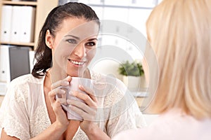 Close up of happy receptionist with cup in hand