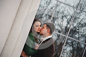 Close up of happy romantic attractive young couple kissing and hugging at the street