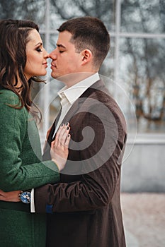 Close up of happy romantic attractive young couple kissing and hugging at the street