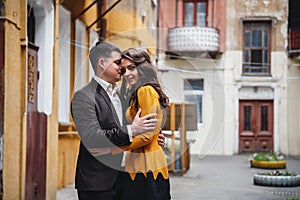 Close up of happy romantic attractive young couple smiling and hugging at the small street, old city